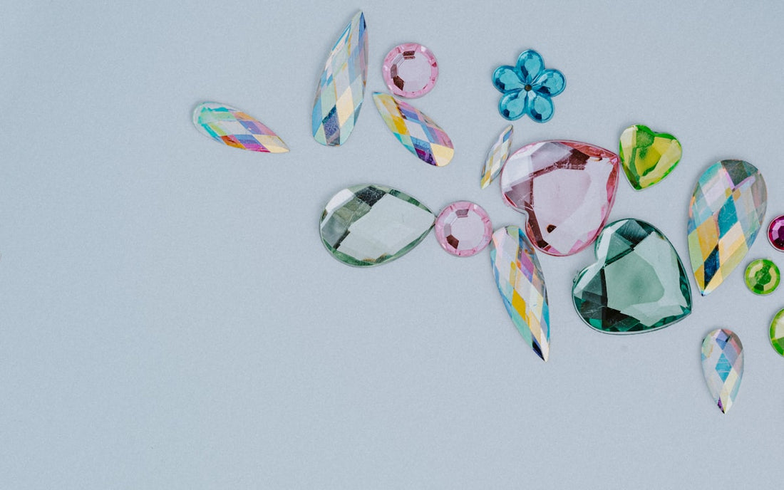 Colorful gemstones on white surface representing birthstone jewelry variety