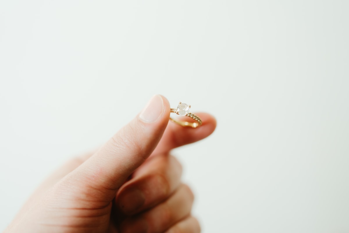Person holding a ring in hand representing ethical jewelry choices and sustainable jewelry materials