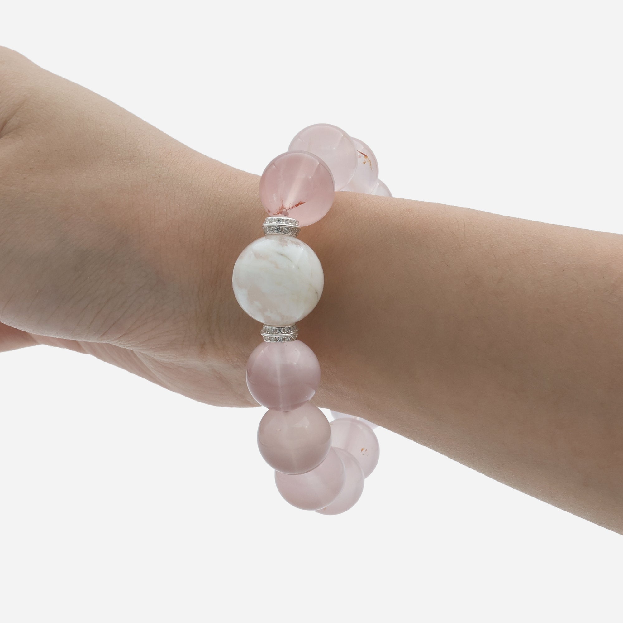 Star rose quartz bracelet worn on wrist displaying the milky pink glow and asterism star effect under natural light