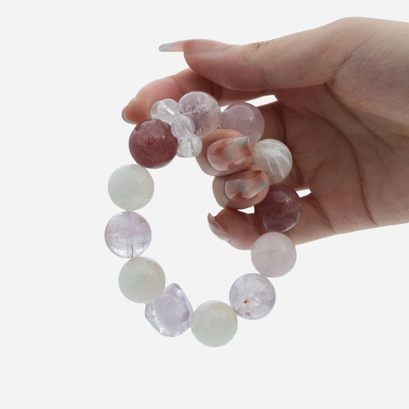 Hand holding the Twilight Bloom multi-gemstone bracelet, showing the chunky 15mm Strawberry Quartz and Amethyst beads.