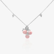 A coquette-style pink queen conch shell necklace featuring three natural shell orbs in a sweet cherry pendant design
