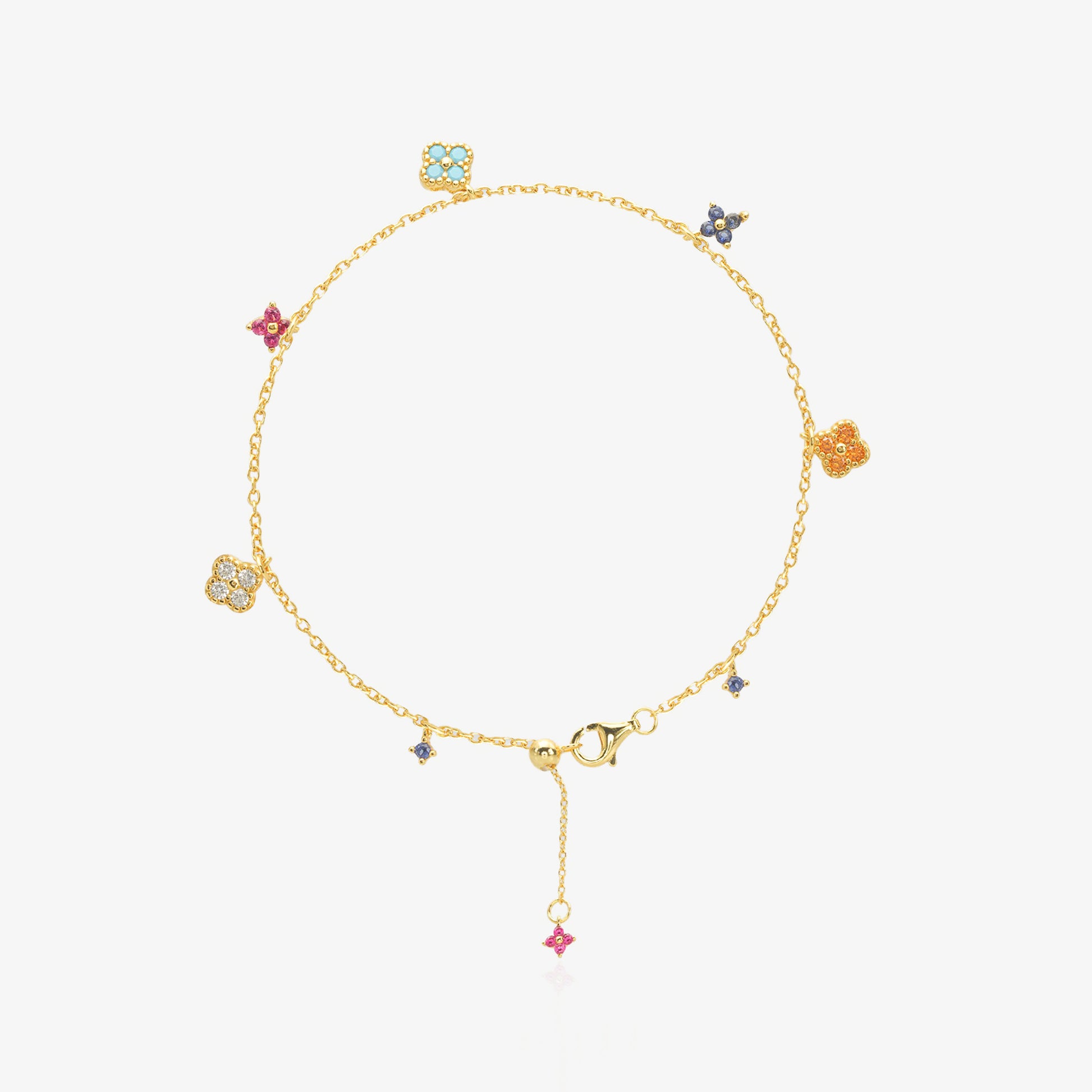 Multi-Color Clover Bracelet — six asymmetrical four-leaf clover charms in pastel pink, orange, sky blue, navy, and ice white stones set in 18K gold-plated O-link chain, flat lay