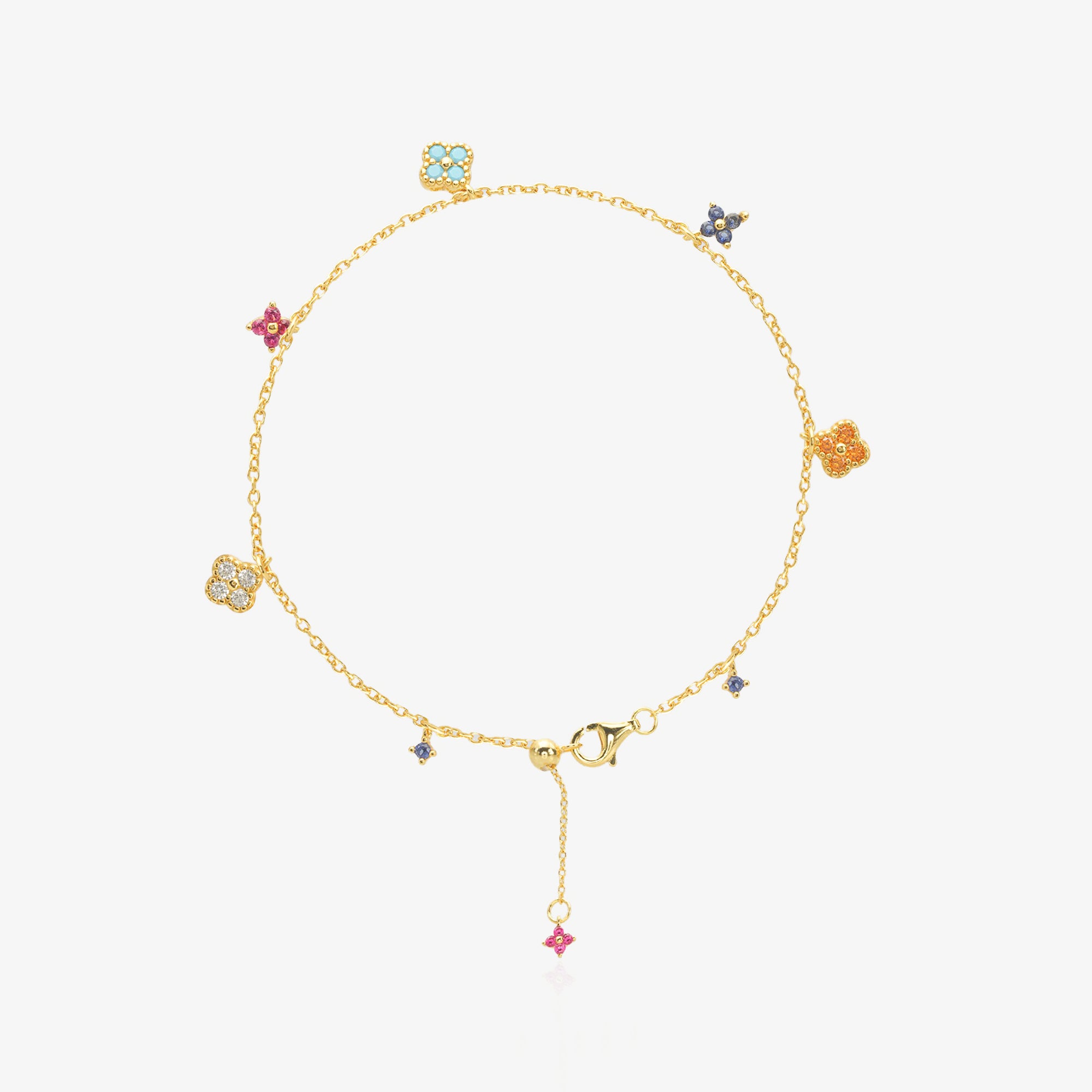 Multi-Color Clover Bracelet — six asymmetrical four-leaf clover charms in pastel pink, orange, sky blue, navy, and ice white stones set in 18K gold-plated O-link chain, flat lay