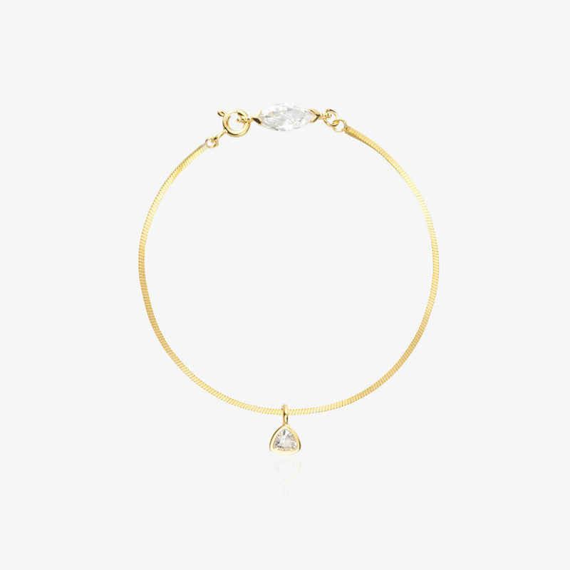 Gold Herringbone Bracelet — flat satin-brushed herringbone chain with horizontal marquise-cut lab diamond near lobster clasp and triangle geometric drop pendant, 18K gold-plated