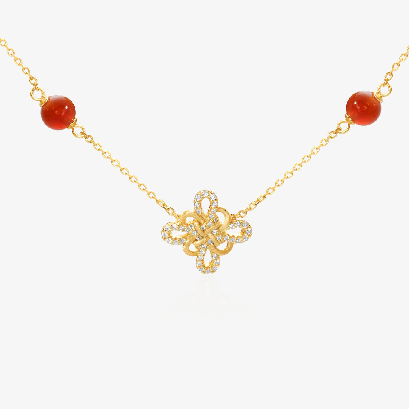 Gold Clover Necklace — Chinese knot pendant shaped as four-leaf clover, natural red agate beads flanking both sides, pavé lab diamond border on outer petals, brushed matte gold finish, O-chain, 18K gold plated sterling silver