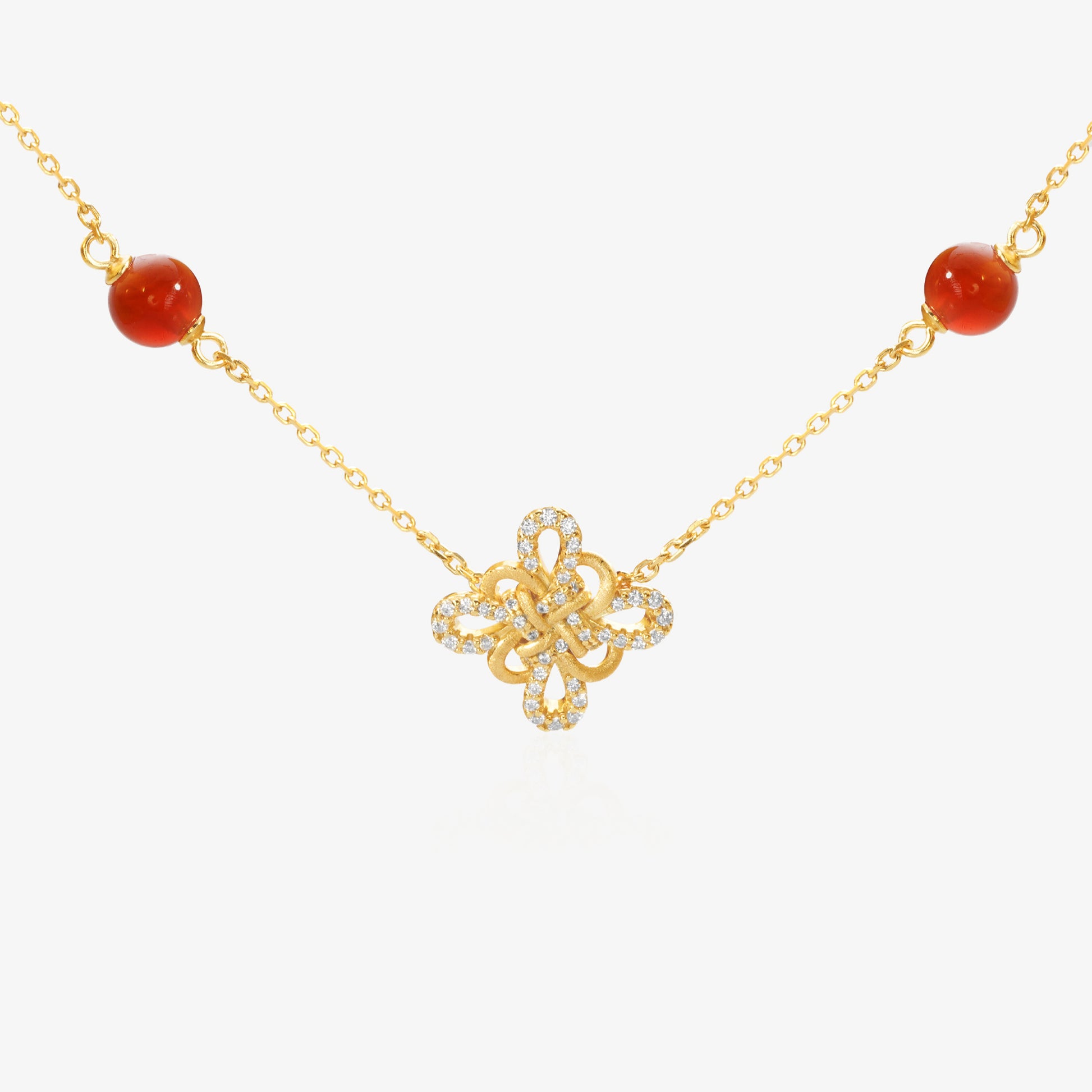 Gold Clover Necklace — Chinese knot pendant shaped as four-leaf clover, natural red agate beads flanking both sides, pavé lab diamond border on outer petals, brushed matte gold finish, O-chain, 18K gold plated sterling silver