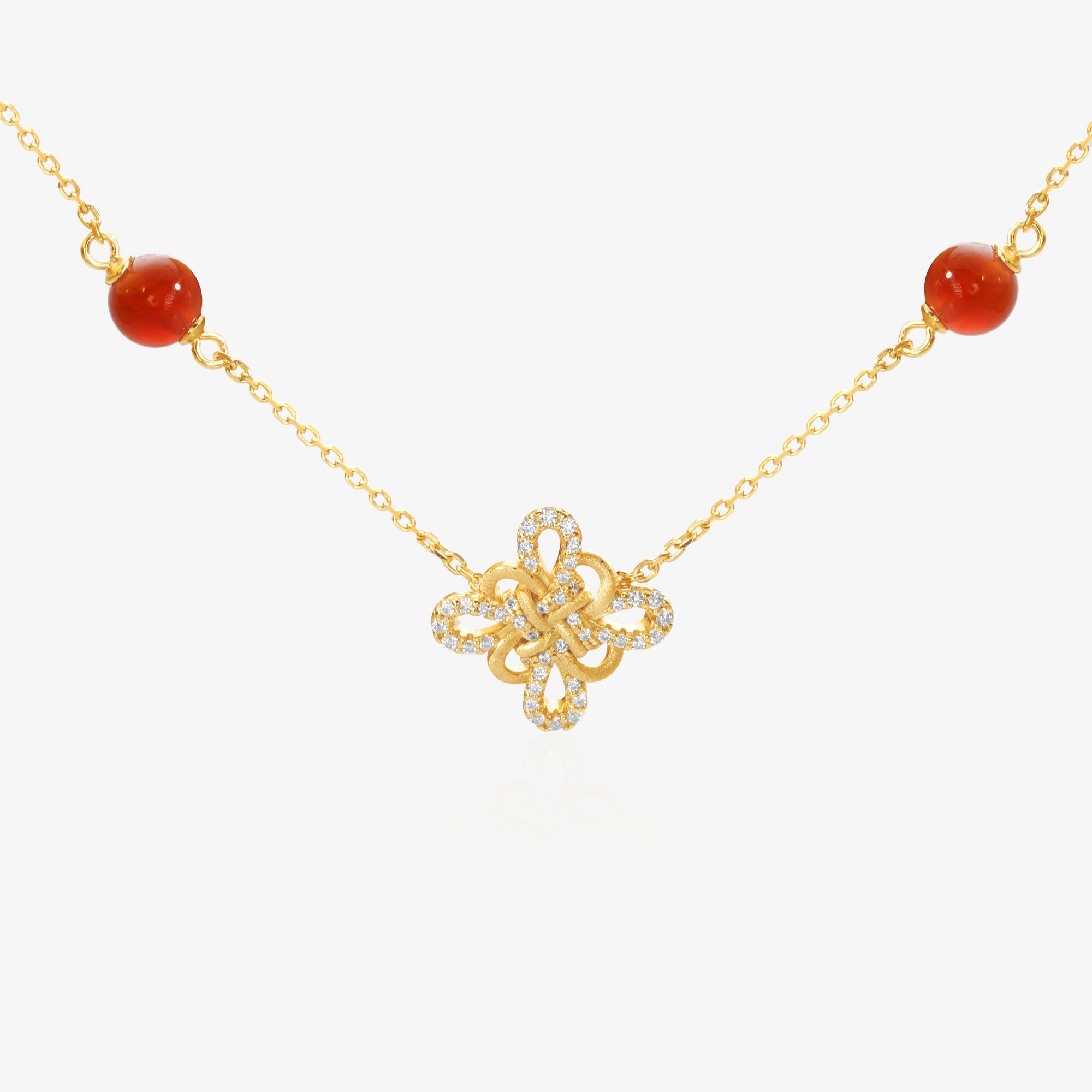 Gold Clover Necklace — Chinese knot pendant shaped as four-leaf clover, natural red agate beads flanking both sides, pavé lab diamond border on outer petals, brushed matte gold finish, O-chain, 18K gold plated sterling silver