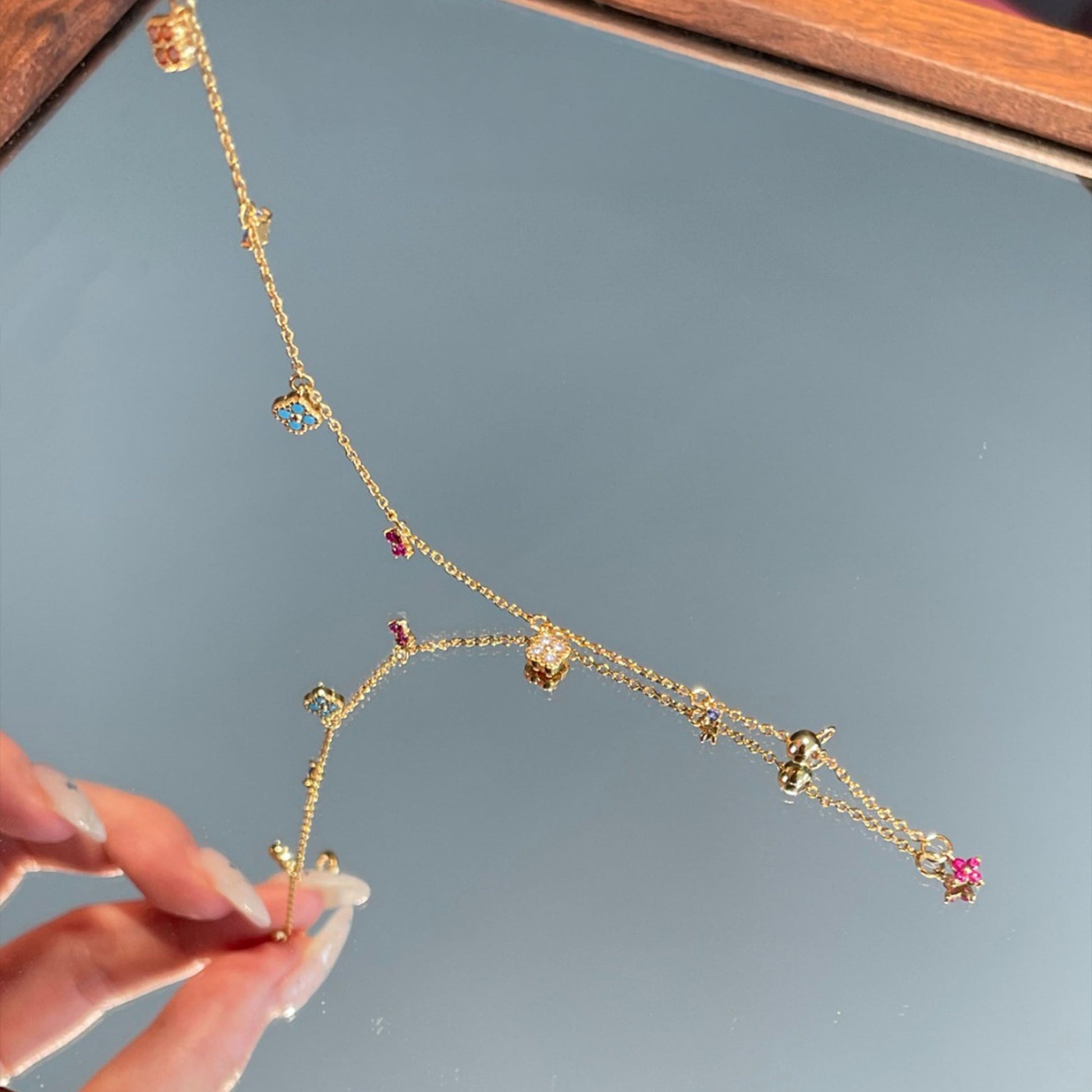 Multi-Color Clover Bracelet full length — 15cm gold-plated chain with lobster clasp, adjustable slider bead, mini pink clover drop on extender tail, all six clovers and three star accents visible