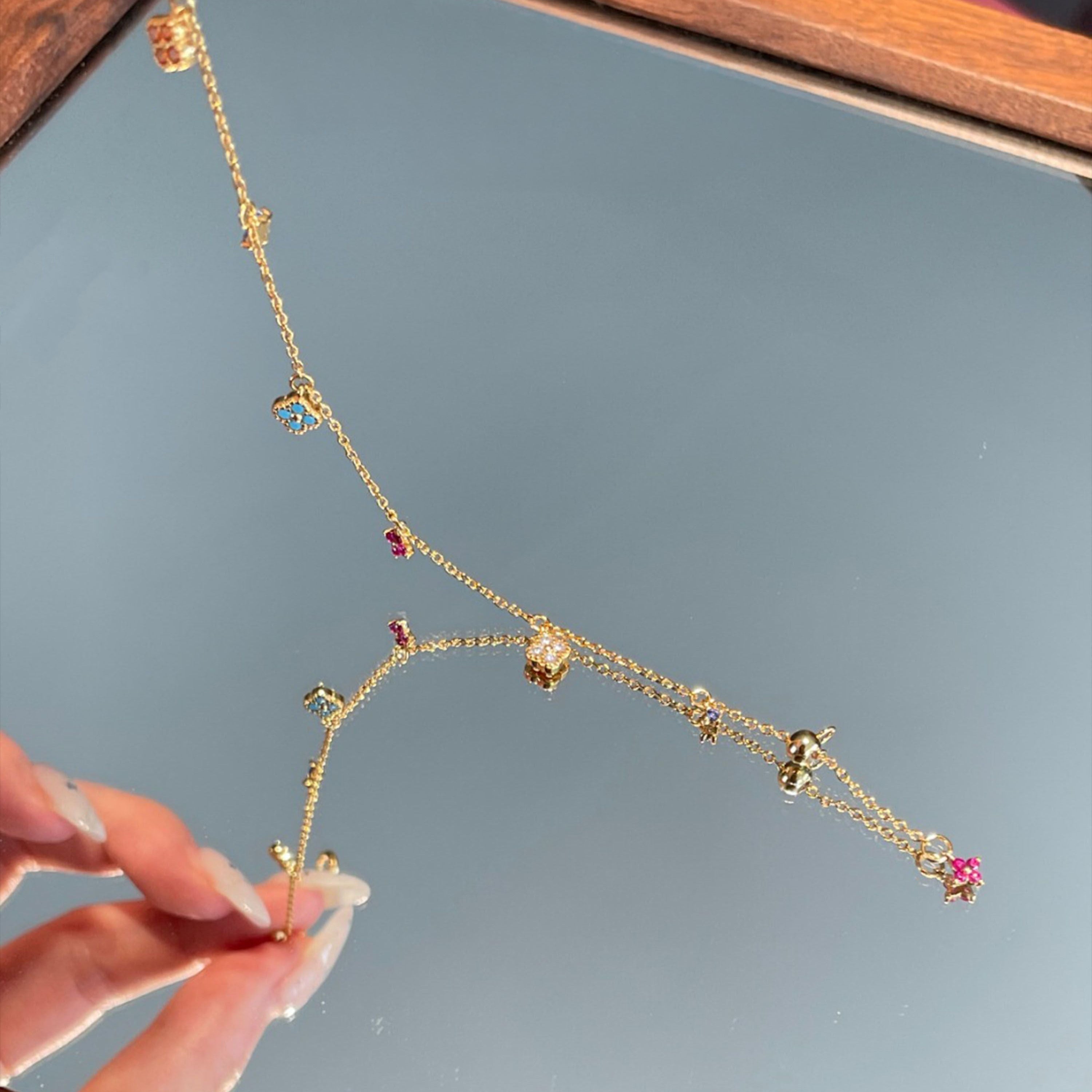 Multi-Color Clover Bracelet full length — 15cm gold-plated chain with lobster clasp, adjustable slider bead, mini pink clover drop on extender tail, all six clovers and three star accents visible