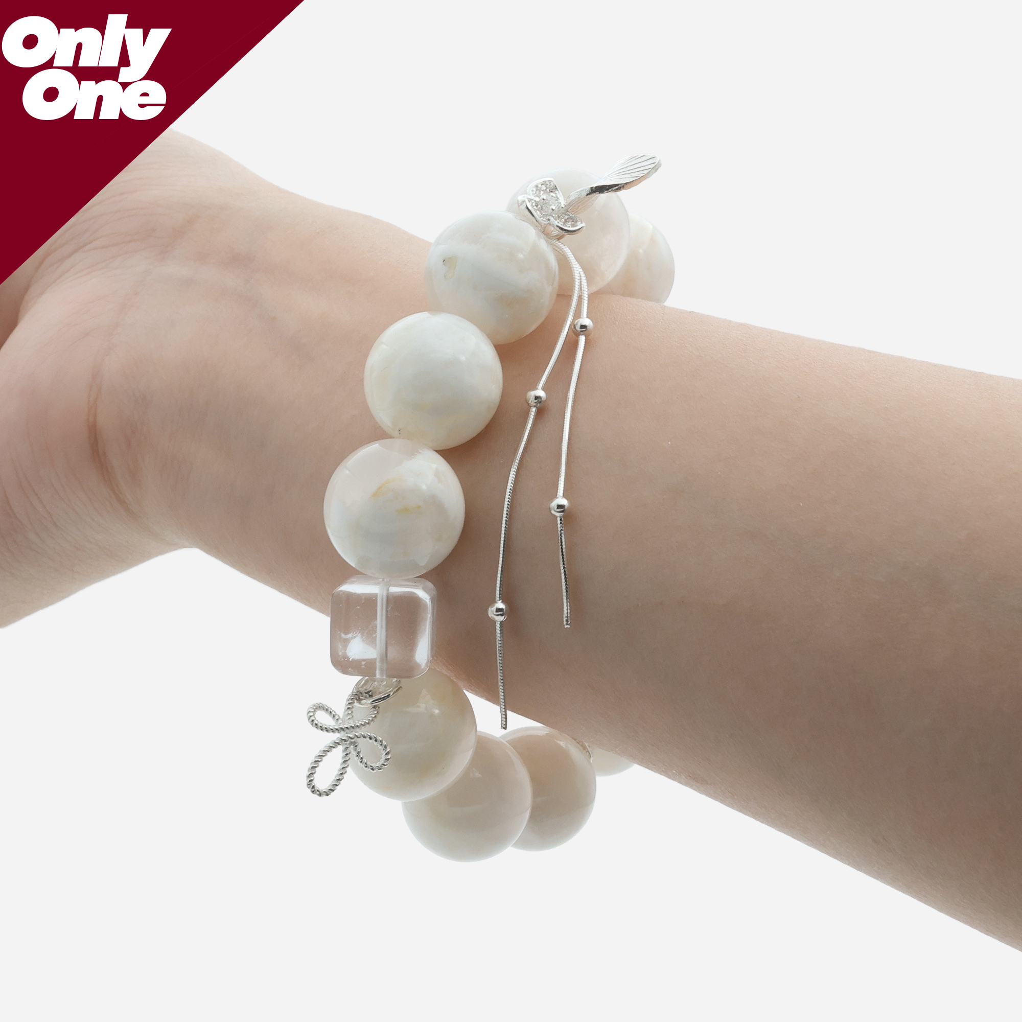 Velvet Snow Ghost Quartz bracelet on wrist, showing the 15mm creamy white beads and fluid 925 silver tassel.