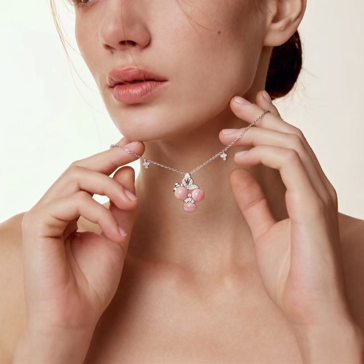 Pink queen conch shell cherry necklace worn on model showing the butterfly chain accents that dance with movement and