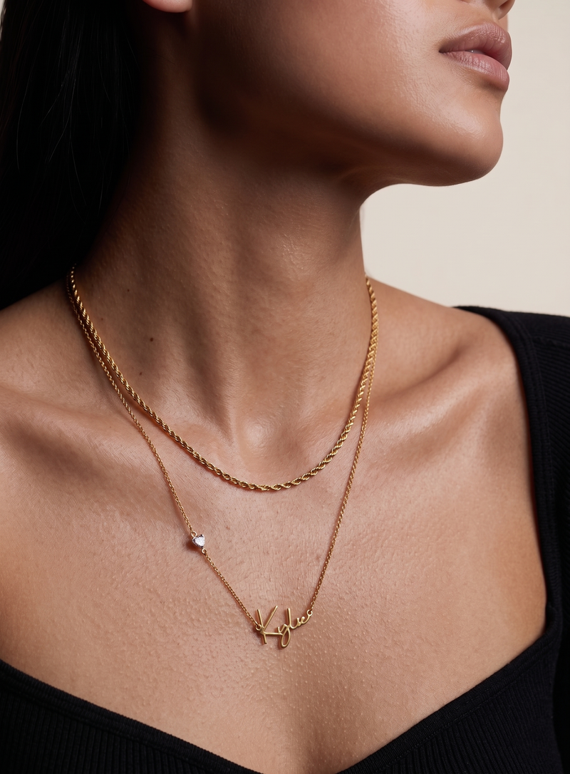 Close-up of custom cursive name pendant in 18K gold plated sterling silver with heart CZ charm detail