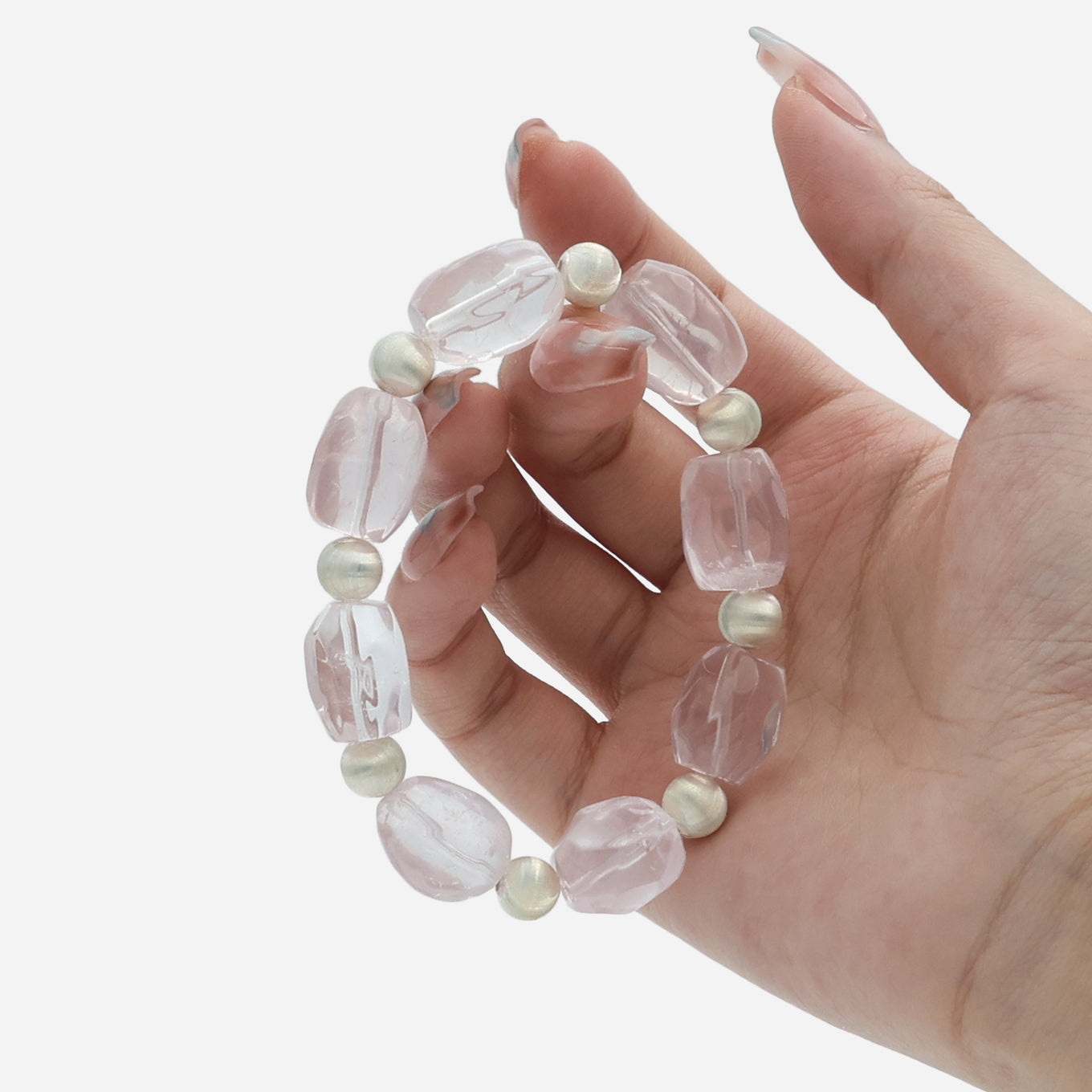 Hand holding natural rose quartz crystal beads showing the genuine pink stone organic shapes and translucent quality