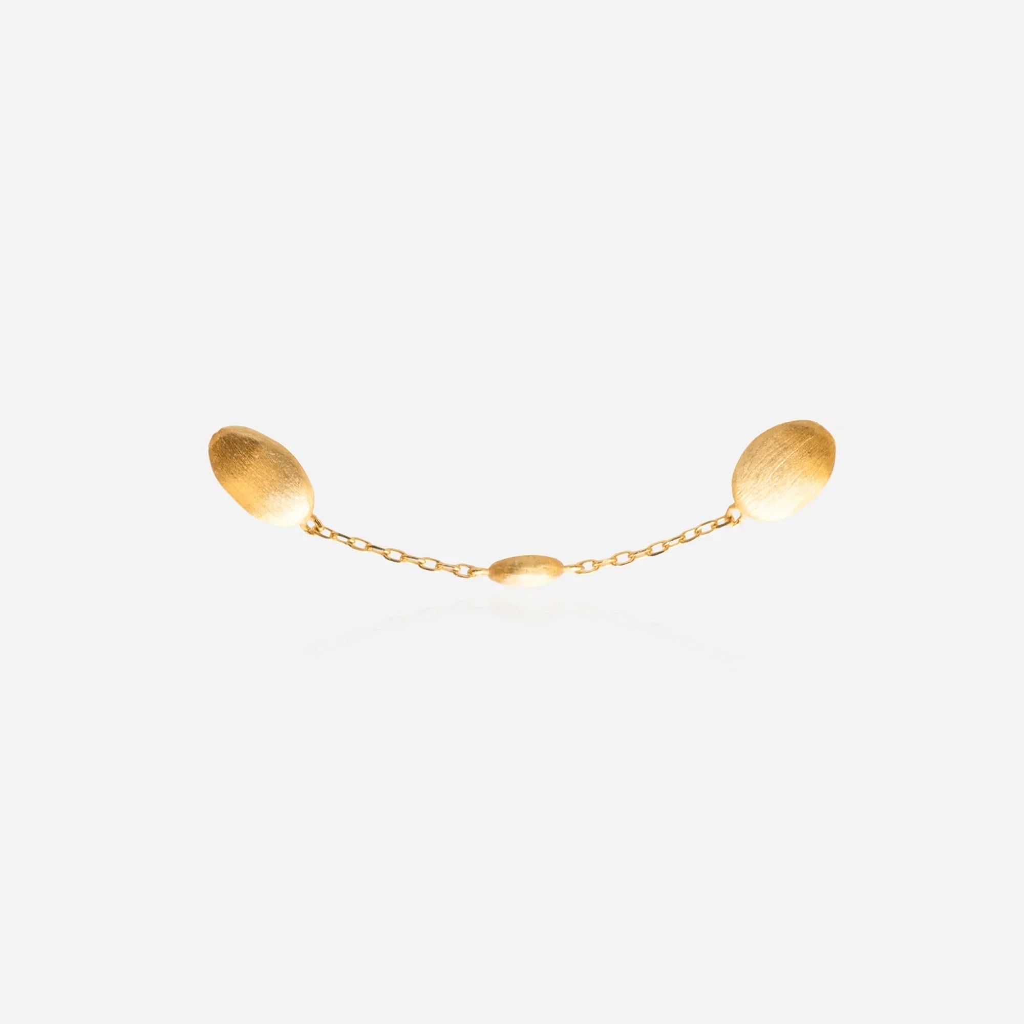 Close-up of satin-finished oval cocoon bead stations on dainty gold chain bracelet showing graduated sizing and matte texture