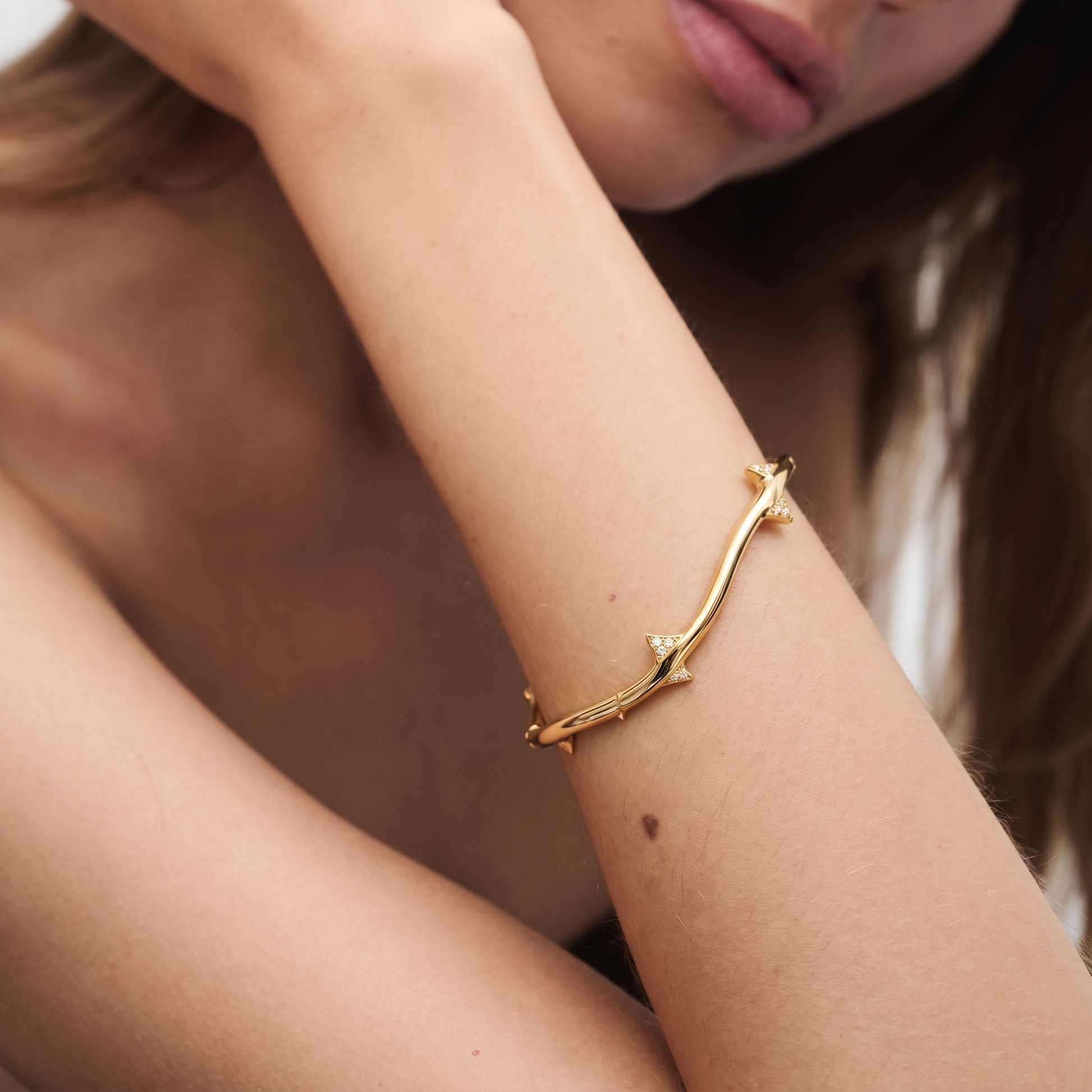 Rose stem hinged bangle detail showing sculptural thorn texture and concealed hinge mechanism in 18K gold on sterling