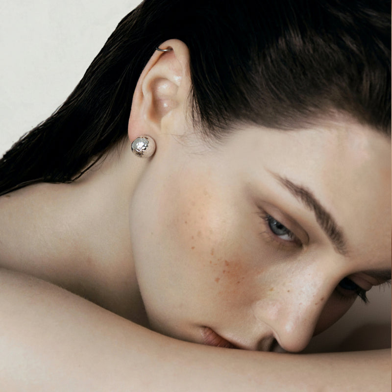 Model wearing hammered silver dome earrings showing texture and fit